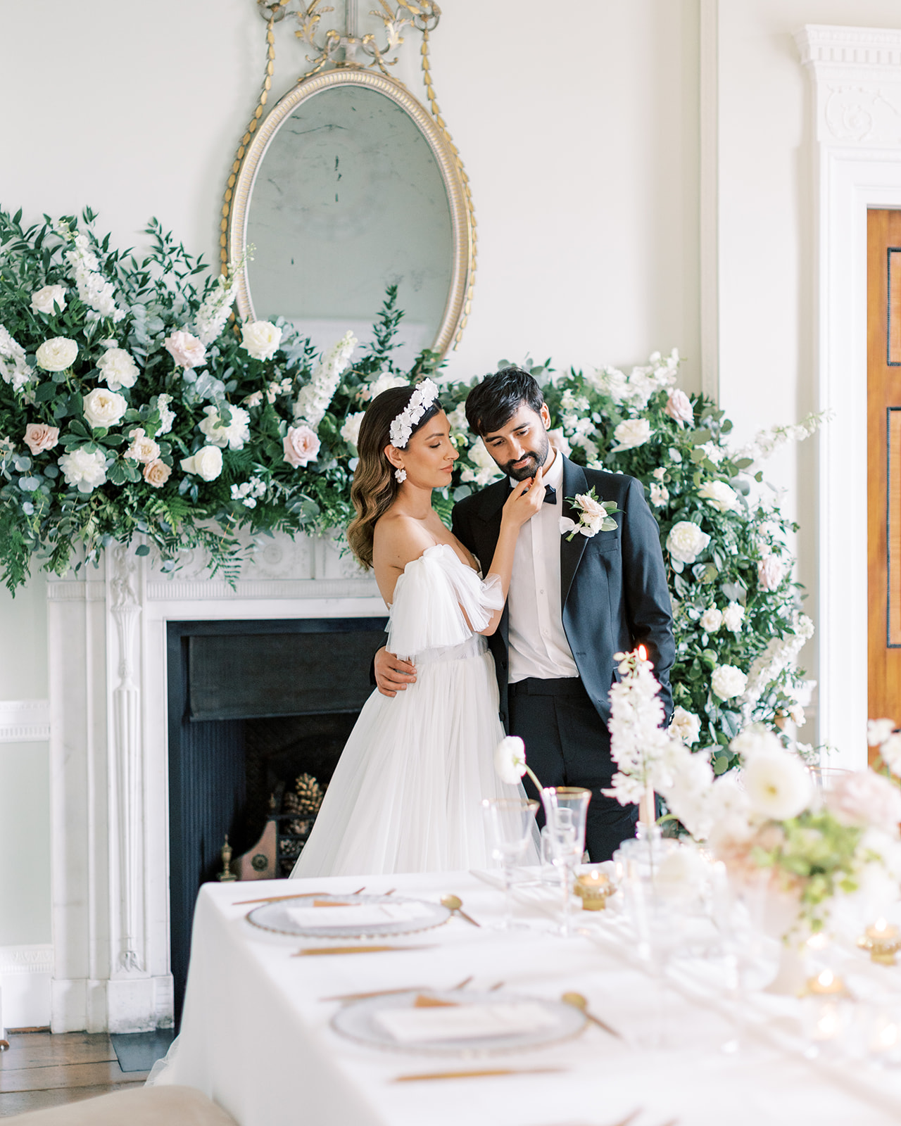 Kelmarsh Hall wedding florist Flourish and Grace with Sophie May Photography, fireplace arrangement with bride and groom