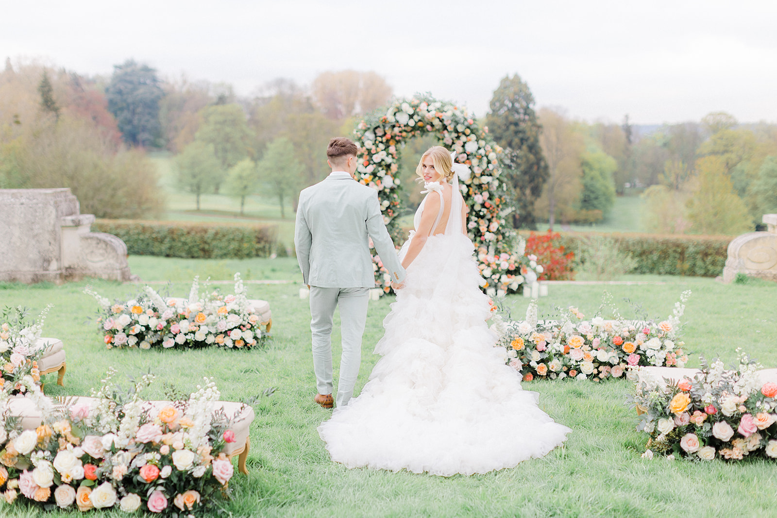 Peach Fuzz Pantone Colour of the Year Wedding flowers luxury florist Flourish and Grace photography by Natalie Stevenson in Paris at Chateau Bouffemont. Flower ceremony arch on lawn