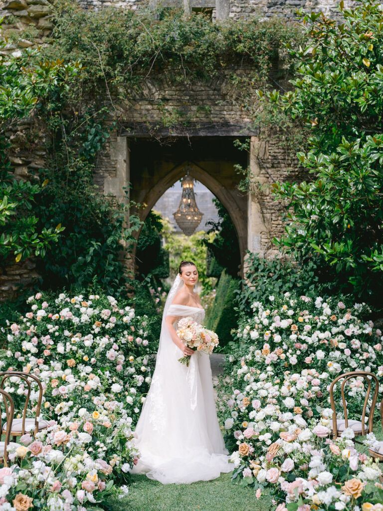 Sophisticated outdoor ceremony aisle flowers with luxury arch at chandelier at Euridge Manor, Cotswolds wedding venue